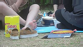 Joven chica asiática muestra sus pies en el parque