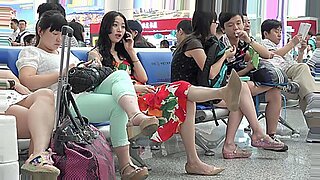 一位亚洲美女在公共机场遭遇中炫耀她的脚。