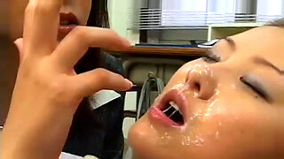 Wanita Jepun seksi menerima pancuran air mani di muka dalam suasana berkumpulan.